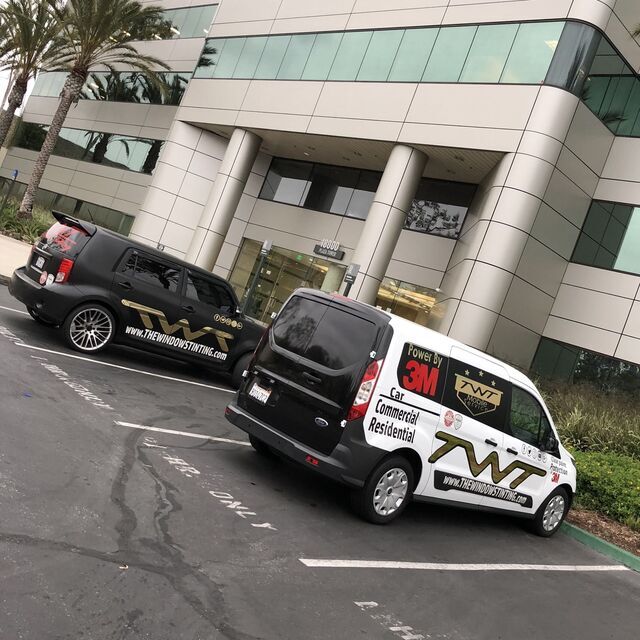 TWT company cars in front of a building